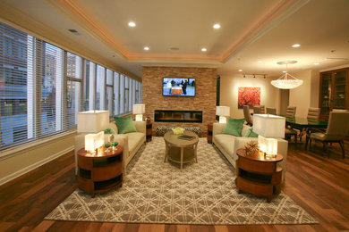 Inspiration for an eclectic open concept medium tone wood floor and brown floor family room remodel in Other with beige walls, a two-sided fireplace, a stone fireplace and a wall-mounted tv