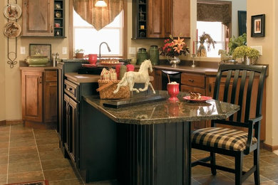Kitchen - traditional kitchen idea in New York with an island, a drop-in sink and black appliances