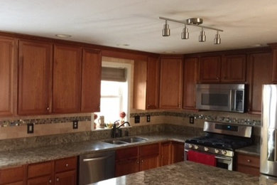 Example of a transitional kitchen design in Boston with an undermount sink, granite countertops, beige backsplash, subway tile backsplash, stainless steel appliances and an island