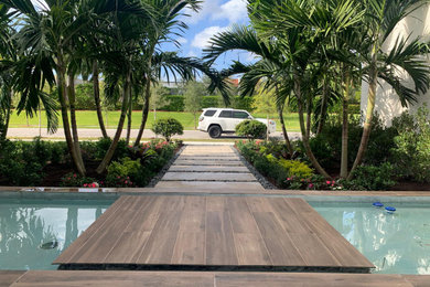 This is an example of a large modern front yard patio in Miami.