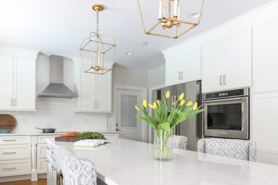 Example of a mid-sized transitional u-shaped medium tone wood floor and brown floor eat-in kitchen design in Jacksonville with an undermount sink, shaker cabinets, gray cabinets, quartz countertops, white backsplash, ceramic backsplash, stainless steel appliances, an island and white countertops