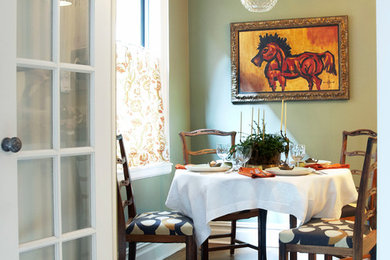 Example of a small classic medium tone wood floor enclosed dining room design in New York with green walls