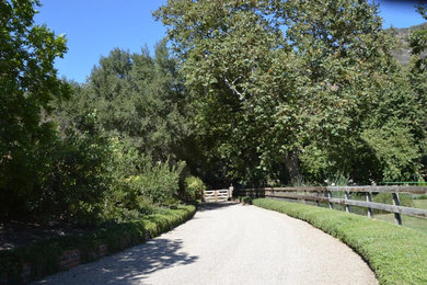 Design ideas for a farmhouse front yard gravel and wood fence landscaping in Santa Barbara.