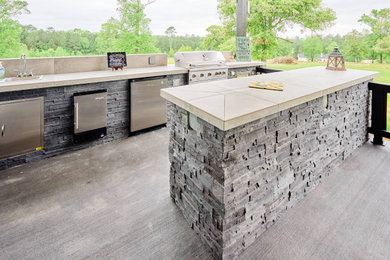 Inspiration for a large country u-shaped concrete floor and black floor kitchen remodel in Houston with a drop-in sink, black cabinets, tile countertops, gray backsplash, cement tile backsplash, stainless steel appliances, two islands and gray countertops