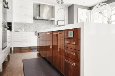Large trendy l-shaped dark wood floor eat-in kitchen photo in Toronto with flat-panel cabinets, white cabinets, solid surface countertops, ceramic backsplash, stainless steel appliances, an island and a double-bowl sink