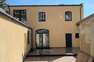 Mittelgroßes, Zweistöckiges Maritimes Einfamilienhaus mit Putzfassade, brauner Fassadenfarbe, Flachdach und schwarzem Dach in Düsseldorf