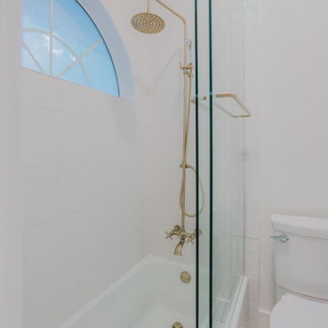 Close-Up of Brass Rain Shower with Arched Window – Argyle Bathroom Detail