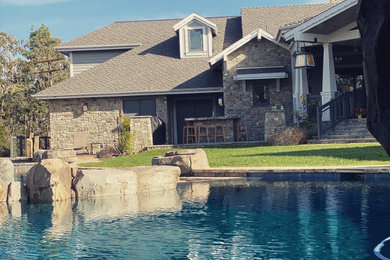 Foto de piscina de estilo americano extra grande en patio trasero con adoquines de piedra natural
