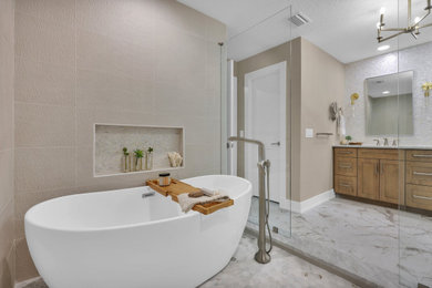 Inspiration for a large coastal master beige tile and ceramic tile marble floor, beige floor and double-sink bathroom remodel in Jacksonville with shaker cabinets, light wood cabinets, a two-piece toilet, beige walls, an undermount sink, marble countertops, white countertops and a built-in vanity