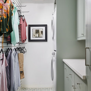 Photo of a medium sized contemporary galley separated utility room in Houston with flat-panel cabinets, green cabinets, engineered stone countertops, white walls, ceramic flooring, a stacked washer and dryer, green floors and white worktops.
