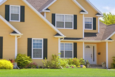Example of a large classic yellow two-story vinyl exterior home design in Other with a shingle roof