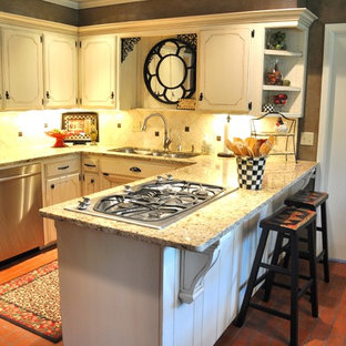 Создайте стильный интерьер: маленькая п-образная кухня в классическом стиле с обеденным столом, тройной раковиной, бежевыми фасадами, столешницей из гранита, бежевым фартуком, фартуком из каменной плитки, техникой из нержавеющей стали, кирпичным полом, фасадами с утопленной филенкой и полуостровом - последний тренд
