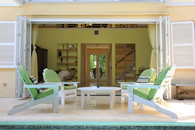 Inspiration for a mid-sized backyard verandah in Miami with a water feature, natural stone pavers and a roof extension.