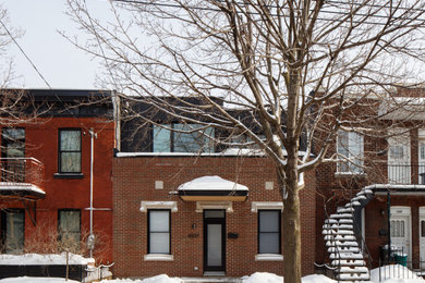 Design ideas for a mid-sized contemporary two-storey brick townhouse exterior in Montreal with a flat roof.