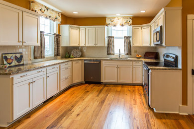 Kitchen - mid-sized traditional u-shaped light wood floor kitchen idea in Other with an undermount sink, shaker cabinets, white cabinets, granite countertops, white backsplash, subway tile backsplash and stainless steel appliances