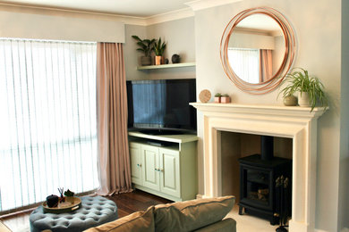 Пример оригинального дизайна: открытая гостиная комната среднего размера с синими стенами, темным паркетным полом, печью-буржуйкой, фасадом камина из камня, отдельно стоящим телевизором и коричневым полом