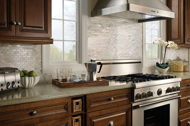 Large elegant l-shaped enclosed kitchen photo in San Francisco with raised-panel cabinets, medium tone wood cabinets, granite countertops, white backsplash, mosaic tile backsplash, stainless steel appliances and an island