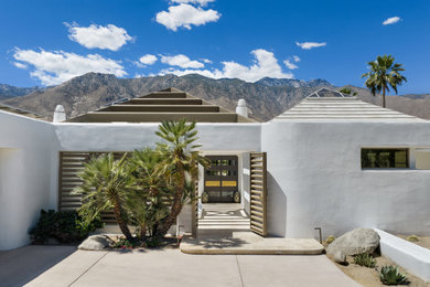 Example of a huge trendy white one-story stucco house exterior design in Other with a brown roof