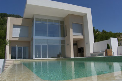 Diseño de fachada de casa blanca grande de tres plantas con revestimiento de estuco, tejado plano y tejado de varios materiales