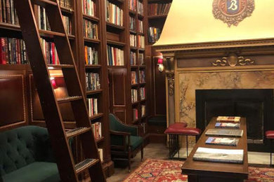 Example of a mid-sized classic freestanding desk medium tone wood floor and brown floor home office library design in Oklahoma City with beige walls, a standard fireplace and a stone fireplace