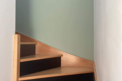 Ejemplo de escalera de tamaño medio con escalones de madera y contrahuellas de madera pintada