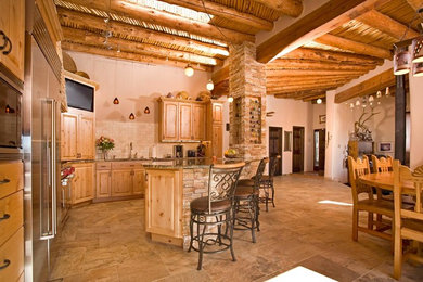 Large mountain style l-shaped travertine floor eat-in kitchen photo in Albuquerque with an undermount sink, raised-panel cabinets, light wood cabinets, granite countertops, beige backsplash, ceramic backsplash, stainless steel appliances and an island