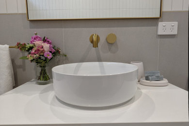 Photo of a mid-sized contemporary kids bathroom in Melbourne with flat-panel cabinets, a freestanding tub, a corner shower, gray tile, ceramic tile, ceramic floors, grey floor, a hinged shower door, white benchtops, a single vanity and a floating vanity.