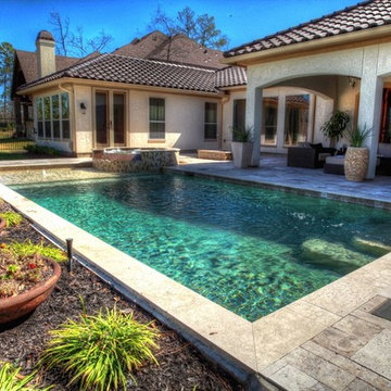 Rectangular pool with walkover water feature, fire pit, and landscape