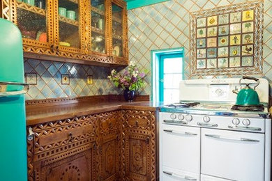 Inspiration for a mid-sized southwestern u-shaped brick floor kitchen remodel in Albuquerque with a double-bowl sink, medium tone wood cabinets, multicolored backsplash, no island, wood countertops, terra-cotta backsplash and colored appliances