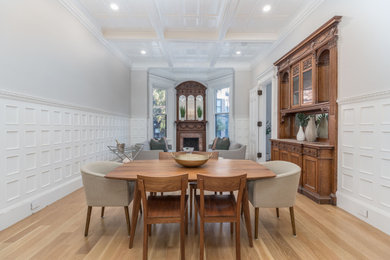 Example of a small transitional coffered ceiling and wainscoting kitchen/dining room combo design in Boston with a standard fireplace