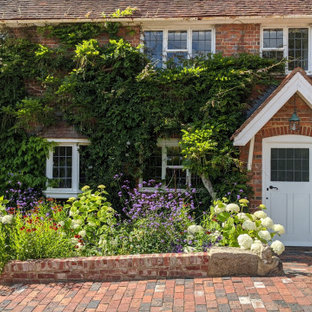 Design ideas for a large traditional back formal full sun garden for summer in Kent with a retaining wall, decorative stones and a stone fence.