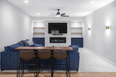 Basement - mid-sized transitional underground carpeted and gray floor basement idea in Minneapolis with gray walls, a standard fireplace and a tile fireplace