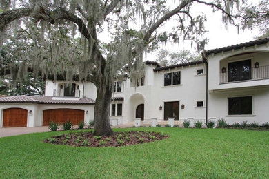 Large mediterranean white two-story stucco house exterior idea in Tampa