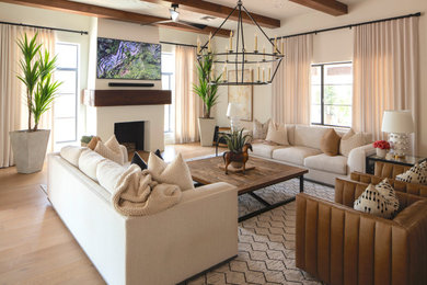 Large transitional open concept light wood floor, beige floor and shiplap ceiling living room library photo in Phoenix with white walls, a wood stove, a plaster fireplace and a wall-mounted tv