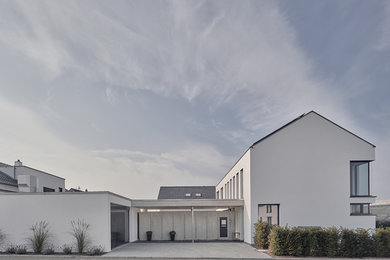 Contemporary stucco white house exterior in Stuttgart with a gable roof and a tile roof.