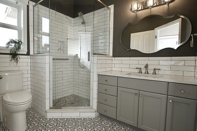 Bathroom - mid-sized transitional white tile and subway tile concrete floor bathroom idea in Seattle with shaker cabinets, gray cabinets, gray walls, quartz countertops and white countertops