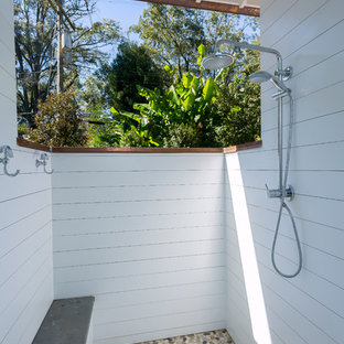 Esempio di un patio o portico stile marinaro con piastrelle e un tetto a sbalzo