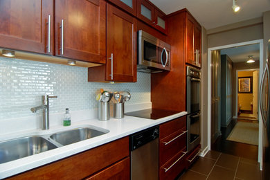 Eat-in kitchen - small contemporary single-wall porcelain tile eat-in kitchen idea in Chicago with a double-bowl sink, shaker cabinets, dark wood cabinets, white backsplash, glass tile backsplash, stainless steel appliances, a peninsula and quartz countertops