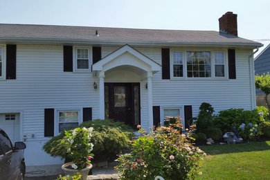 Large white two-story exterior home photo in New York