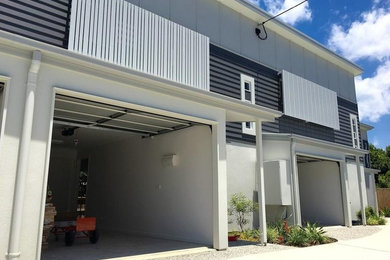 This is an example of a small contemporary two-storey multi-coloured townhouse exterior in Sunshine Coast with concrete fiberboard siding, a flat roof and a metal roof.