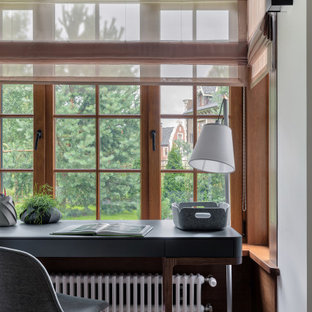 Modelo de despacho madera y boiserie, contemporáneo, boiserie, con paredes grises, suelo de madera en tonos medios, escritorio independiente, suelo marrón y boiserie