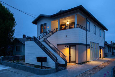 Diseño de fachada de casa blanca y gris tradicional renovada pequeña de dos plantas con revestimiento de aglomerado de cemento, tejado a dos aguas y tejado de metal