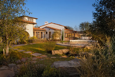 Inspiration for a huge mediterranean white three-story stucco gable roof remodel in Orange County