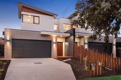 Inspiration for a contemporary two-storey duplex exterior in Melbourne with mixed siding and a metal roof.