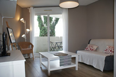 Exemple d'une salle de séjour chic avec un mur gris, parquet clair et un sol marron.