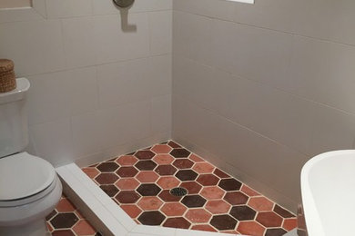 Mid-sized contemporary master bathroom in Raleigh with a freestanding tub, a corner shower, a one-piece toilet, red tile, cement tile and white walls.