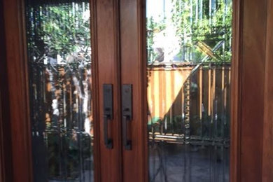 Entryway - mid-sized traditional terra-cotta tile and gray floor entryway idea in Los Angeles with white walls and a glass front door