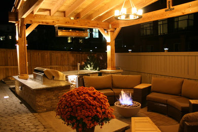 Large transitional backyard patio kitchen photo in Calgary with a pergola