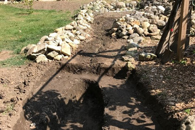 This is an example of a mid-sized rustic full sun backyard gravel retaining wall landscape in Chicago for summer.