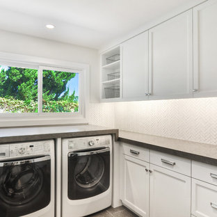 Medium sized traditional u-shaped separated utility room in Orange County with white cabinets, a side by side washer and dryer, white walls, grey worktops, shaker cabinets, limestone worktops, limestone flooring and grey floors.